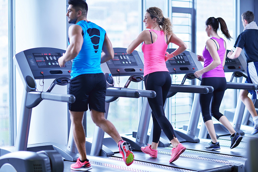 Group of people running on treadmills